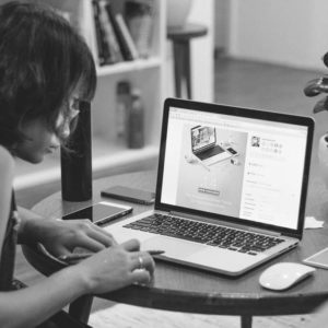 a person sitting in front of a laptop on a table